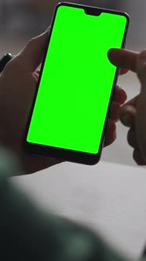 Person Holding Modern Smartphone with Vivid Green Chroma Key Screen in Closeup View Showcasing Blank