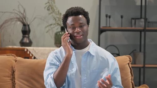 Young Man Talking on Phone, Sitting on Couch