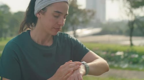 Woman Using Smartwatch before Morning Workout in Park