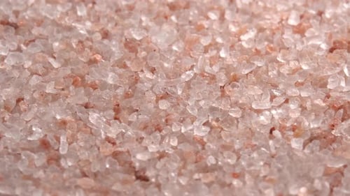 Pink himalayan salt or rock salt rotating close up background side light. Trace minerals salt used
