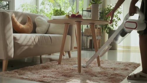 Woman Vacuuming a Shag Rug at Home