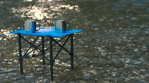 Camping Table and Mugs in a Stream