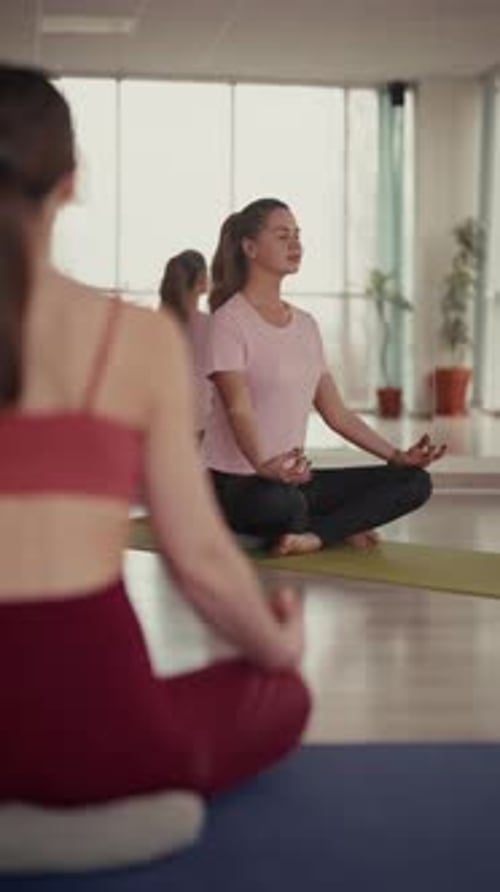 Women Practicing Yoga in Bright Studio