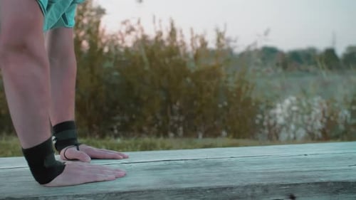 A Young Guy Does PushUps In The Early Morning In Nature Behind Lake Or A Quarry