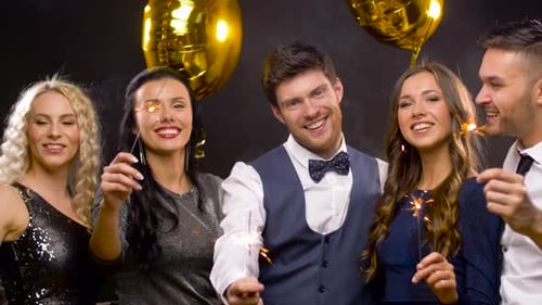 Smiling Friends Celebrate Holding Sparklers at Party