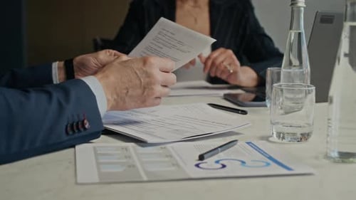 Businessman and Businesswoman Signing Contract in Boardroom