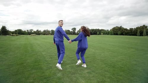 Couple in Love Running in the Park Holding Hands