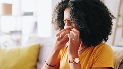 Woman with Cold Using Tissue Indoors