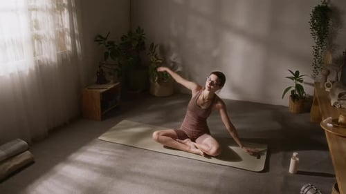 Woman Stretching and Exercising on Yoga Mat Indoors