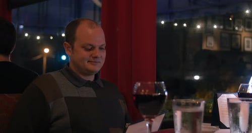 Man looks at menu in restaurant at night