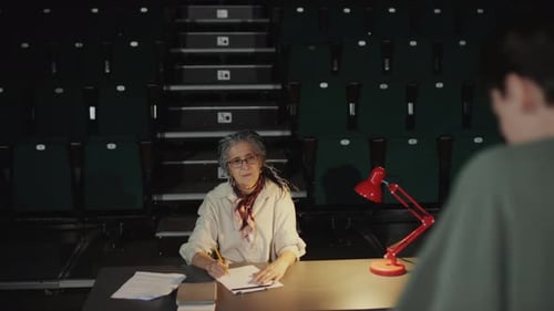 Director de casting viendo al actor actuar en el escenario durante una audición en el teatro