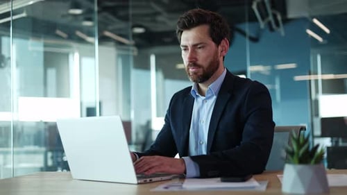 Focused Programmer Sitting By Table and Working By Modern Computer in Office