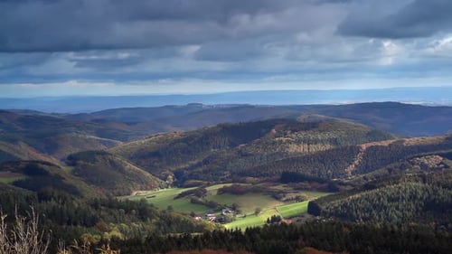 Grünes Tal mit Häusern, umgeben von Hügeln und Wäldern, Landschaft, Zeitraffer