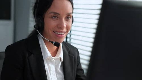 Smiling Woman Working at Computer with Headset