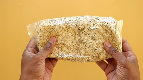 Hands Holding Bag of Rolled Oats