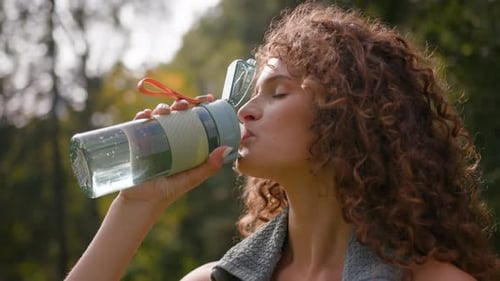 Young Woman Drinks Water After Outdoor Workout