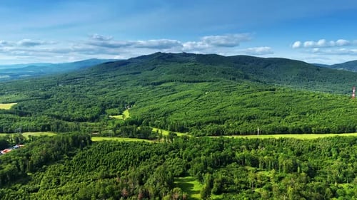 Spectacular mountains covered with green forests. Electrical transmission line crosses the landscape