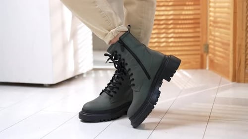 Person wearing khaki pants and dark green boots