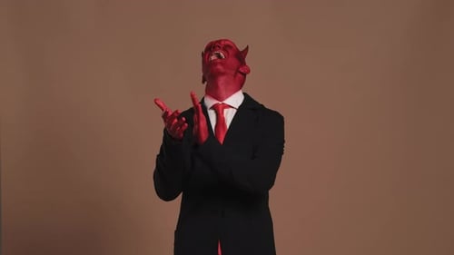 Empresario con maquillaje de diablo aplaudiendo
