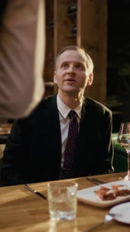 Vertical of Middle-Aged Man Paying by Credit Card for Restaurant Dinner