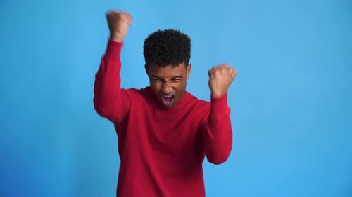 Excited Man Celebrates Good News Against Blue Background