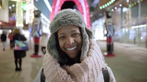 Woman Smiling on City Street at Night