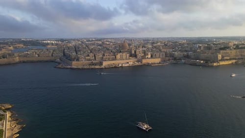 Epic wide aerial drone footage of Valletta's complete fortified peninsula surrounded by deep blue