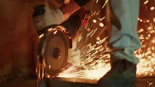 Steady Worker Slicing Metal Amidst Flying Sparks Bright Sparks Fly As Worker Cuts Metal on Ground