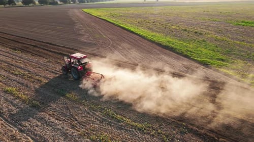 Tractor Working in Agricultural Field Cultivating and Plowing Dry Soil