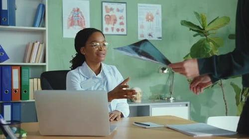 Female Doctor Explains X-Ray Results to Male Patient