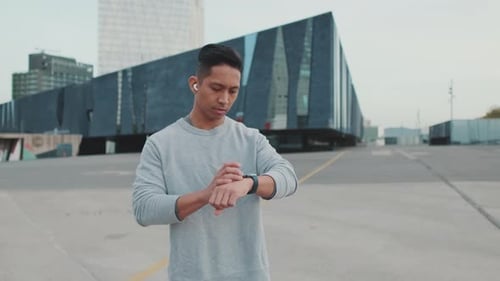 Man Jogging Outdoors Checks Smartwatch Progress