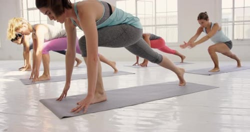 Women Practice Yoga in Bright Studio Together