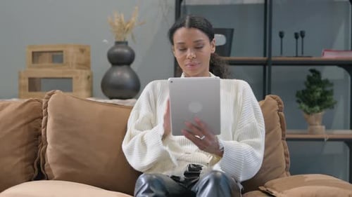 Woman Relaxing on Couch Using Tablet at Home