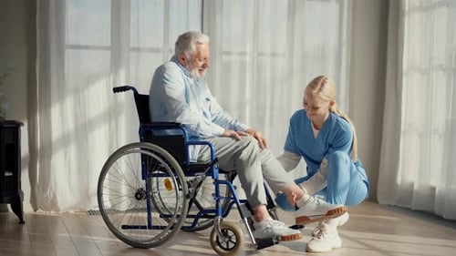 Healthcare Worker Helping Senior Man With Foot Exercise