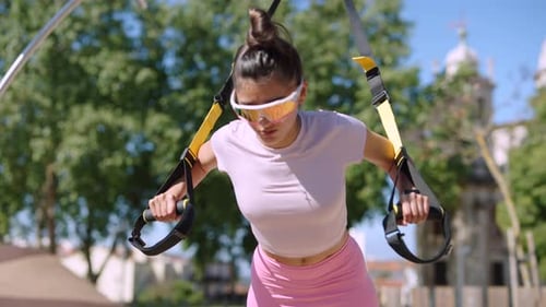 Young Woman Exercising Outdoors with Resistance Straps
