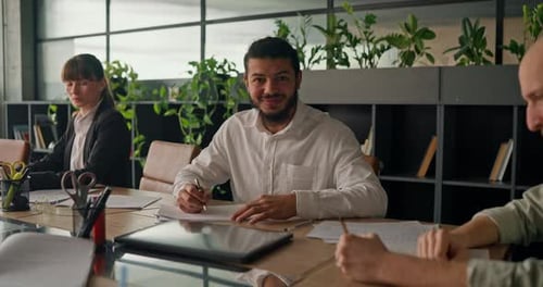 African Office Worker Takes Notes While Working with Colleagues Actively Engaging in Teamwork and