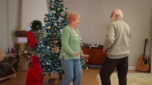 Senior Couple Dancing by Christmas Tree
