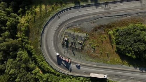 Aerial View of Sharp Highway Bend with Trucks and Cars