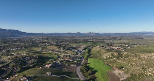 Aerial View of Green Valley with Hot Air Balloons
