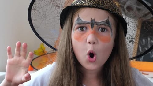 Girl in Witch Hat Makes Faces Into Camera
