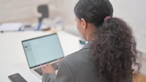 Rare View of African Business Woman Typing on Laptop