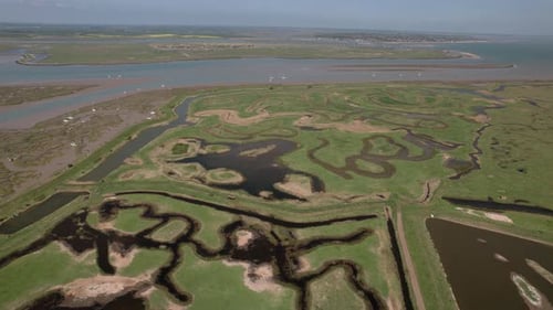 Marshes And Creek In Tollesbury On The Coastline Of Essex In The UK. aerial sideways