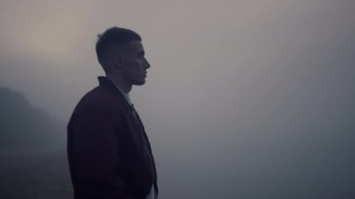 Upset man screaming on sea beach at sunrise taking off stress in foggy weather