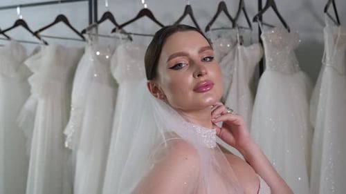 Glamorous Bride Poses in Front of Dresses