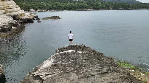 man on rock watching sea