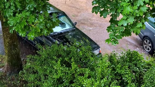 Rain Pouring Down on Parked Cars Beneath a Tree - High Angle Shot