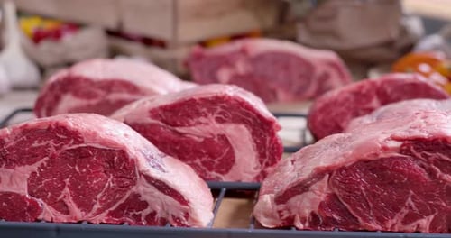 Close up of Raw Beef Ribeye Steaks on Rack