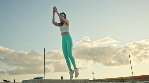 Athletic Woman Performing Squat Jumps on Sunny Day