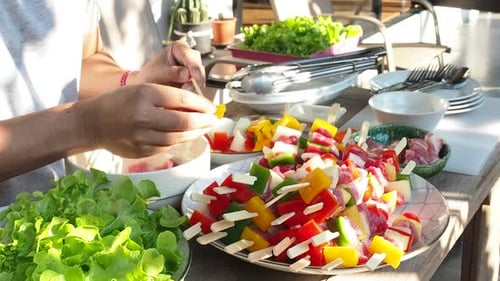 A man preparing barbecue outdoors for friends.