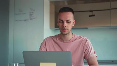 Man Working on Laptop at Home During Daytime
